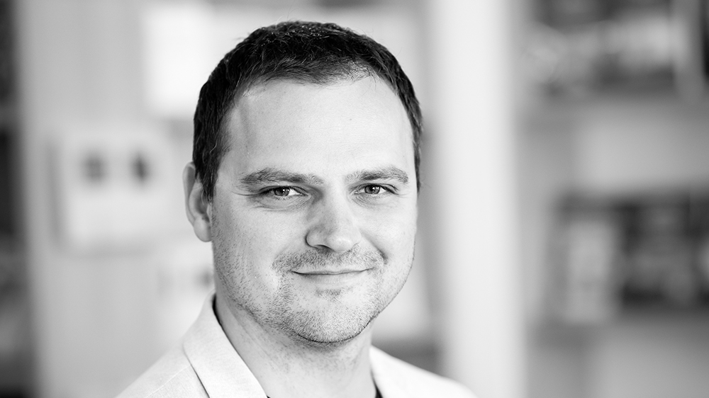 A middle age man looking straight forward. Slightly smiling. Photo of Kristian Novak.